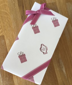 A box gift wrapped in Louise Lewis branded paper