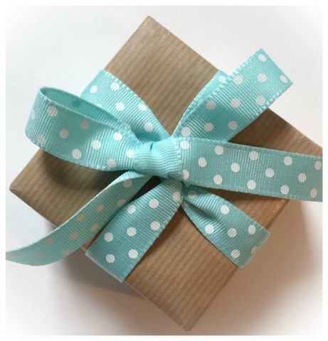 Parcel wrapped in kraft giftwrap with a spotty ribbon
