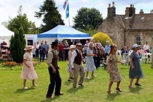Visitors to the 1940s Home Front Vintage Fair 2017 dancing on the grass
