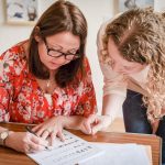 Angela, founder of Creative Calligraphy & a workshop attendee looking at a calligraphy worksheet