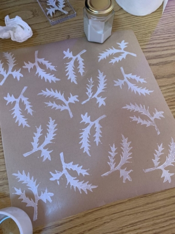 Lino printed fern design in white on craft paper