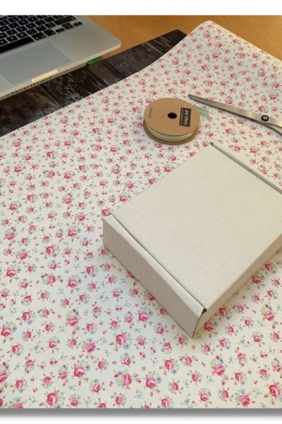 Wrapping paper, ribbon & scissors laid out ready for an online wrapping class